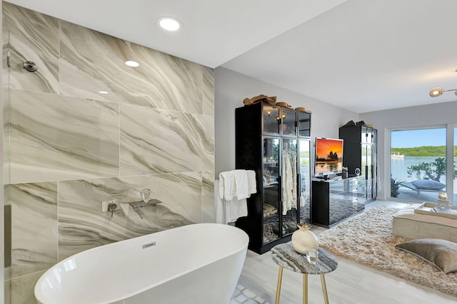 bathroom with tile walls and separate shower and tub