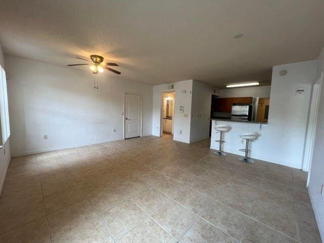 unfurnished living room with ceiling fan