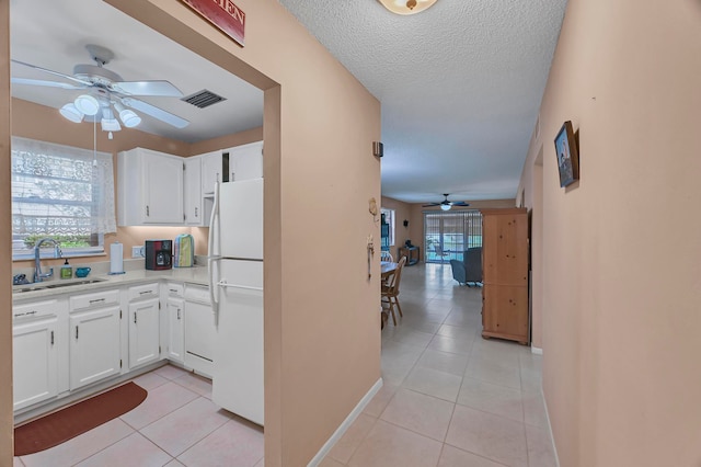 interior space featuring white appliances, ceiling fan, white cabinetry, and sink