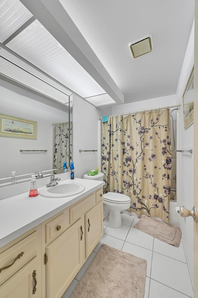 full bathroom with vanity, shower / bath combo with shower curtain, toilet, and tile patterned floors