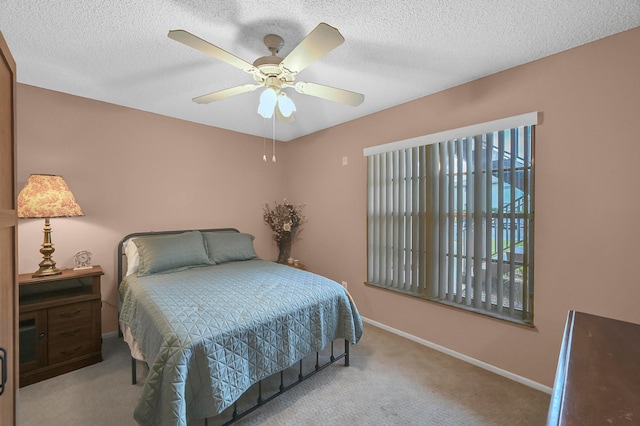 bedroom featuring ceiling fan, a textured ceiling, and light carpet