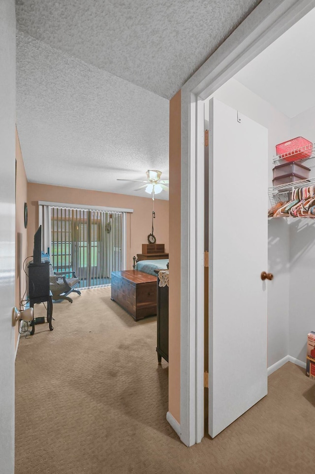 hall with carpet floors and a textured ceiling