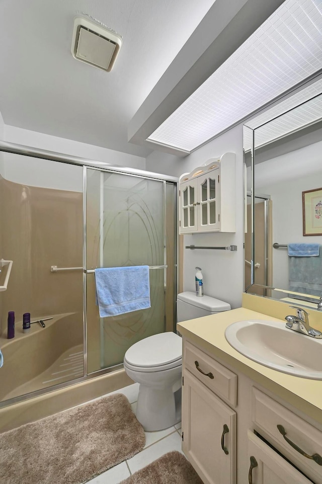 bathroom featuring walk in shower, vanity, toilet, and tile patterned floors