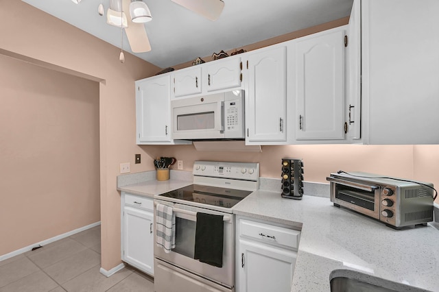 kitchen featuring white cabinets, stainless steel electric range, ceiling fan, and light tile patterned flooring