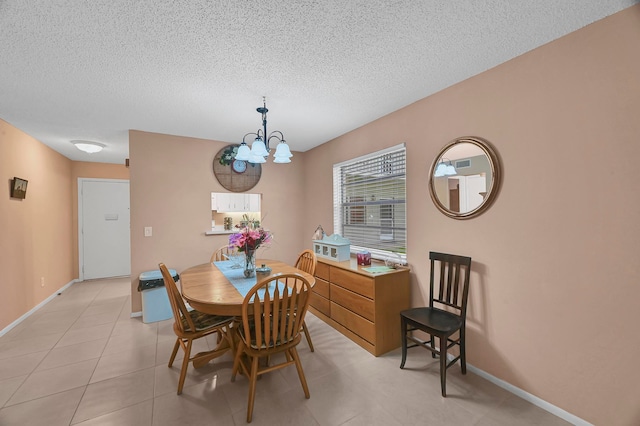 tiled dining space with a chandelier and a textured ceiling