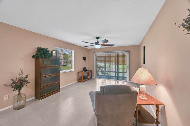 living room with ceiling fan and a textured ceiling