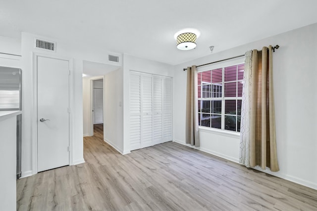 unfurnished bedroom featuring light hardwood / wood-style floors and a closet