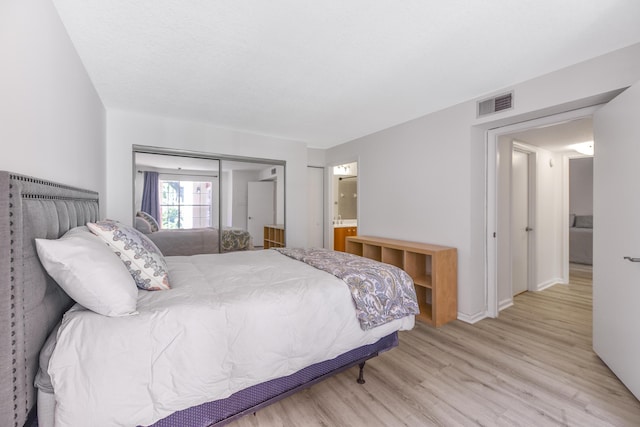 bedroom with a closet and light hardwood / wood-style floors