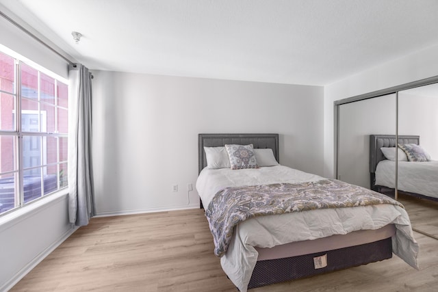 bedroom with light wood-type flooring and a closet