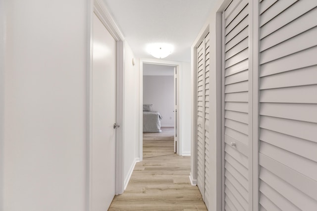 corridor with light hardwood / wood-style floors