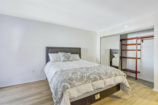 bedroom with light hardwood / wood-style floors and a closet