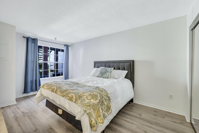 bedroom featuring a textured ceiling and light wood-type flooring