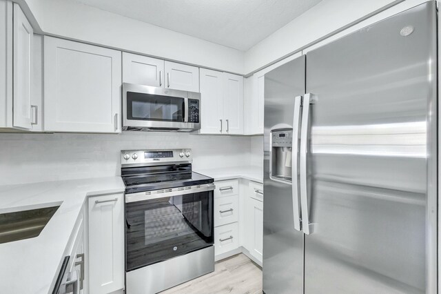 laundry room featuring separate washer and dryer, light hardwood / wood-style flooring, and sink