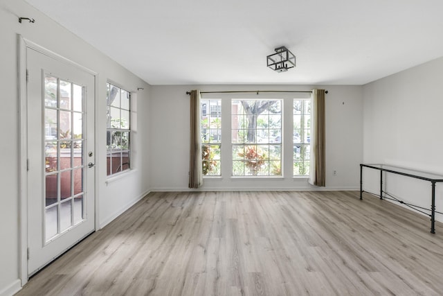 unfurnished room featuring a healthy amount of sunlight and light wood-type flooring