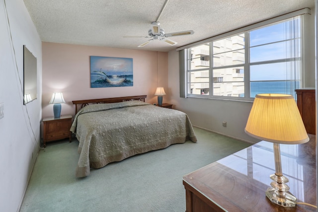 bedroom featuring ceiling fan, a textured ceiling, and carpet flooring