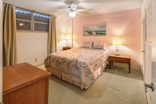 carpeted bedroom with ceiling fan and a textured ceiling