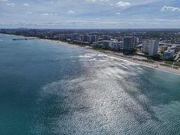 drone / aerial view featuring a water view and a beach view