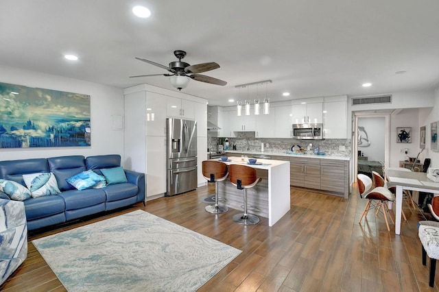 living room featuring ceiling fan and dark hardwood / wood-style floors