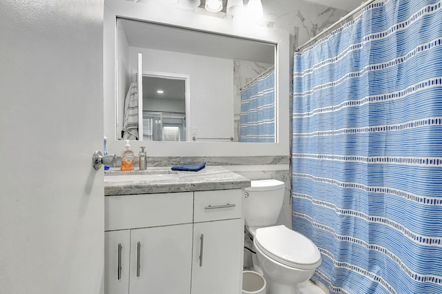 bathroom with curtained shower, vanity, and toilet