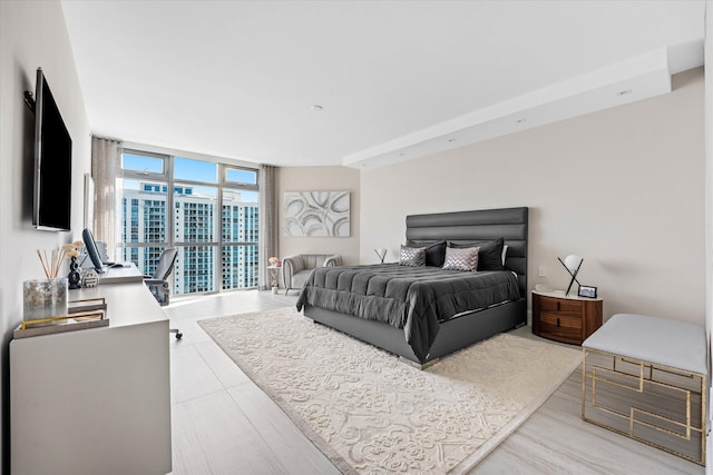 bedroom featuring a wall of windows and light hardwood / wood-style floors