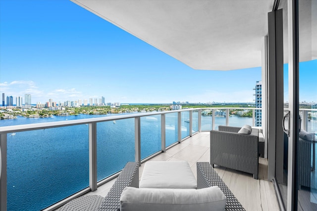 balcony with an outdoor living space and a water view