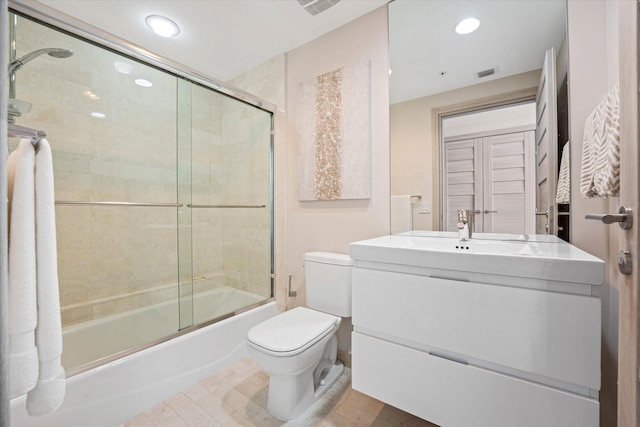 full bathroom with combined bath / shower with glass door, vanity, and toilet