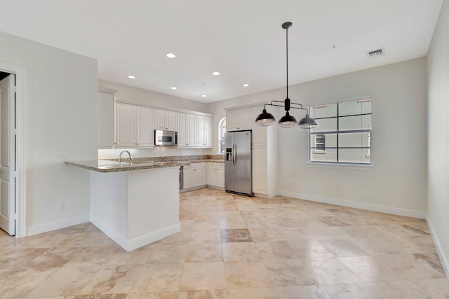 kitchen with white cabinets, kitchen peninsula, stone countertops, decorative light fixtures, and appliances with stainless steel finishes