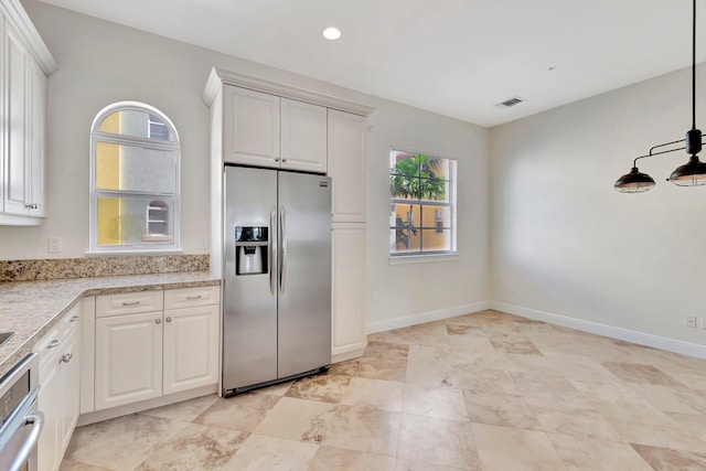 kitchen featuring white cabinets, appliances with stainless steel finishes, light stone countertops, and decorative light fixtures