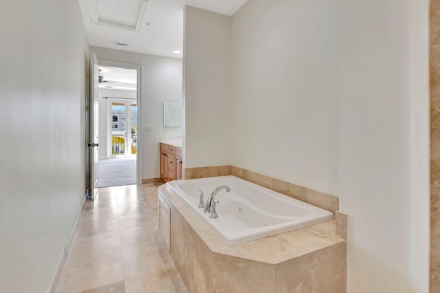 bathroom featuring vanity, tile patterned floors, and a relaxing tiled tub