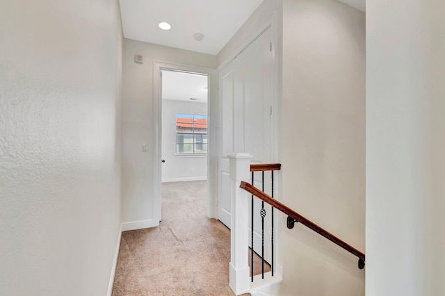 hall featuring light colored carpet