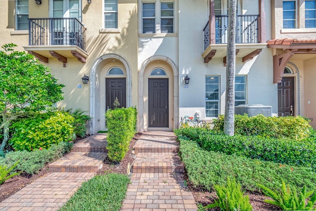 property entrance featuring a balcony and central AC unit