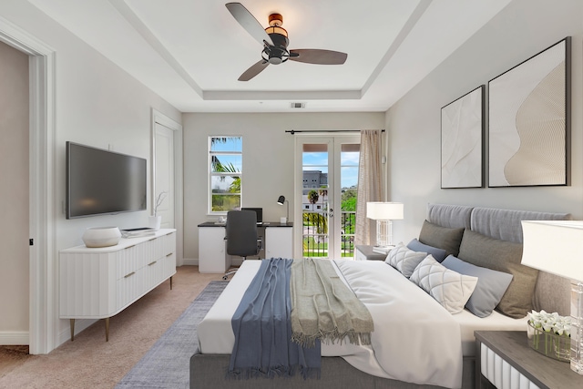 carpeted bedroom with ceiling fan, a raised ceiling, and access to exterior