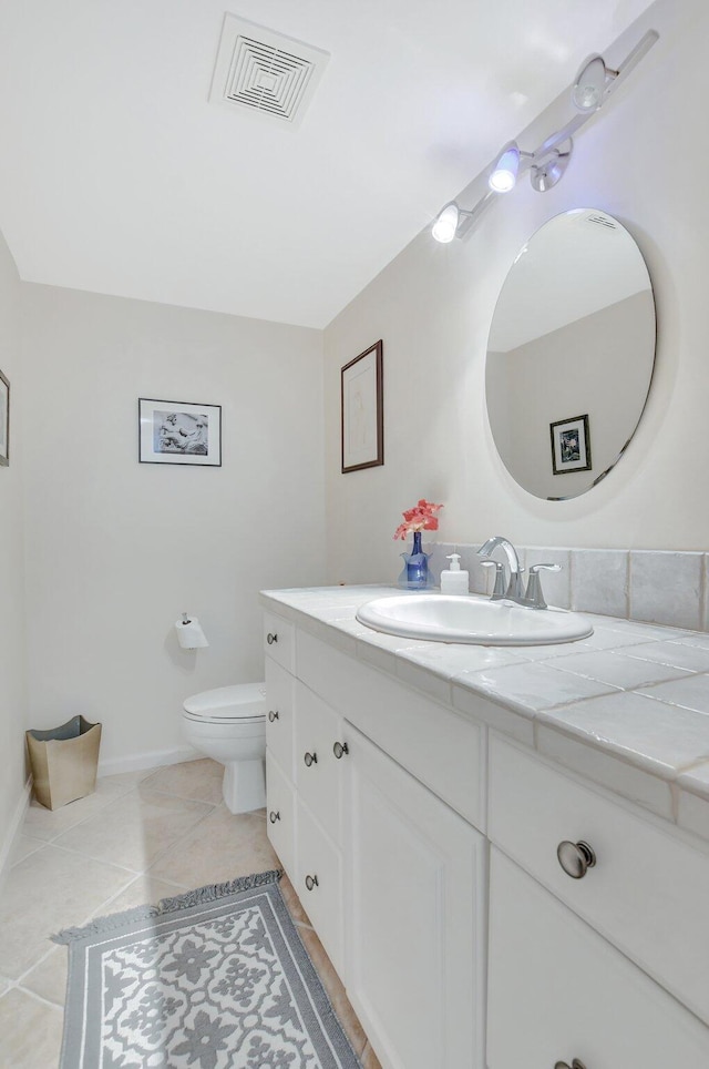 bathroom with tile patterned flooring, vanity, and toilet