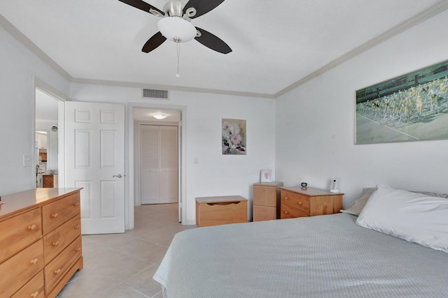 tiled bedroom with a closet, ceiling fan, and crown molding