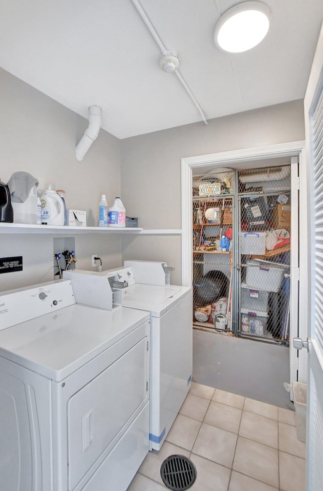 laundry area featuring light tile patterned floors and washer and dryer