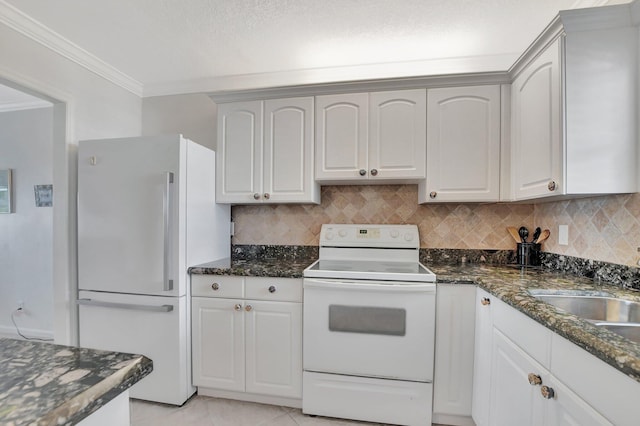 kitchen with white cabinets, ornamental molding, white appliances, dark stone counters, and decorative backsplash