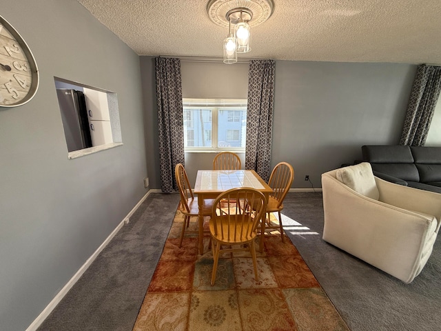 dining area with dark carpet and a textured ceiling