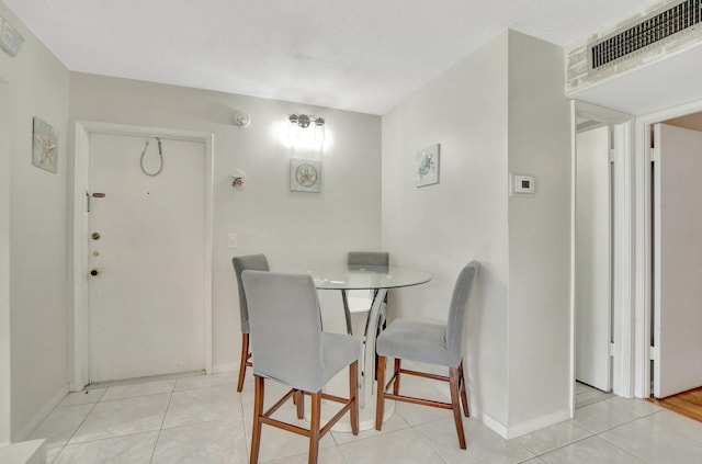 dining area with a textured ceiling and light tile patterned floors