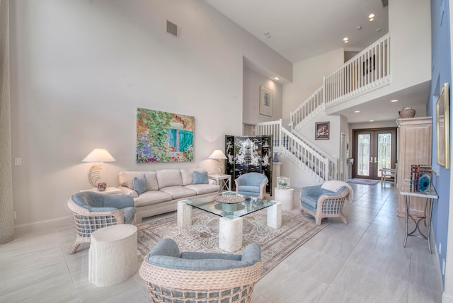 tiled living room featuring a towering ceiling and french doors