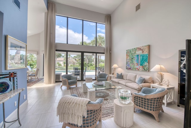 tiled living room with a high ceiling and french doors