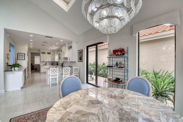 dining area with a chandelier and high vaulted ceiling