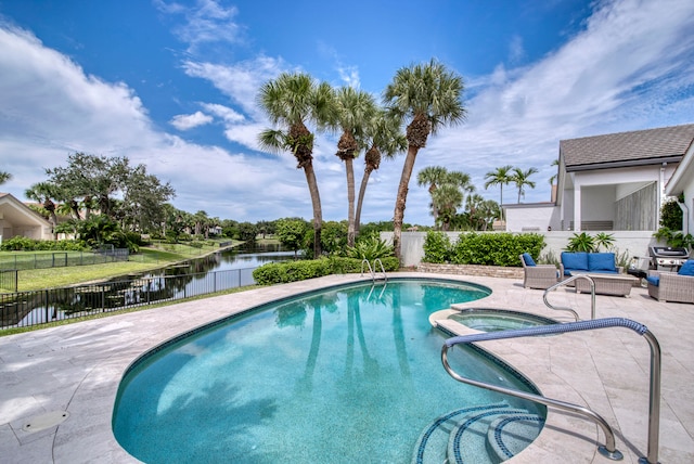 view of pool with a patio, a water view, and an in ground hot tub