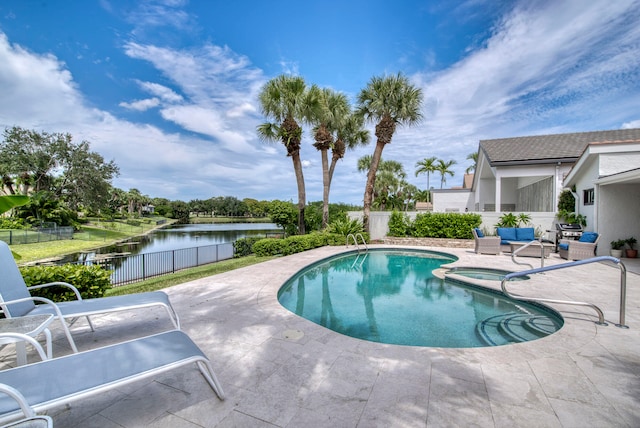 view of pool featuring a patio and a water view