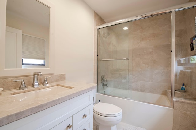 full bathroom featuring enclosed tub / shower combo, vanity, and toilet