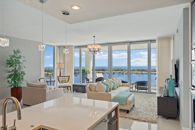 dining area with a wall of windows, a water view, an inviting chandelier, and a wealth of natural light