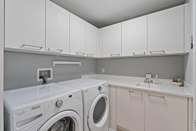 laundry room featuring cabinets, washer and clothes dryer, and sink