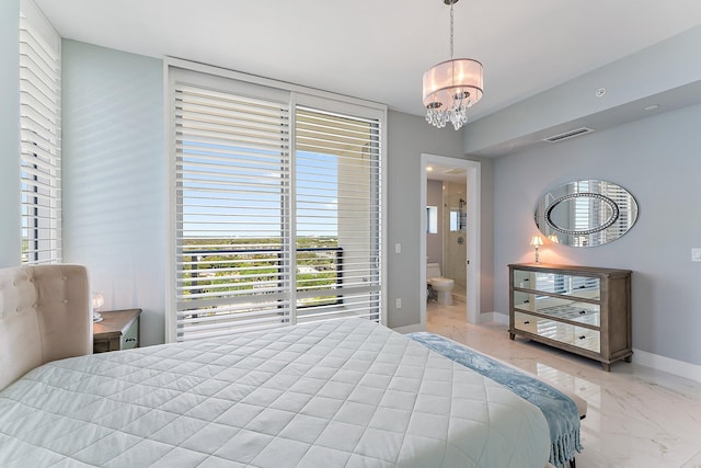 bedroom with a notable chandelier and connected bathroom