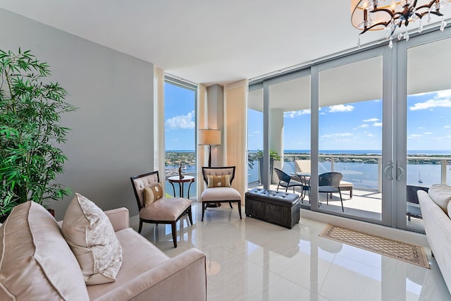 living room with a chandelier, a water view, and a wealth of natural light