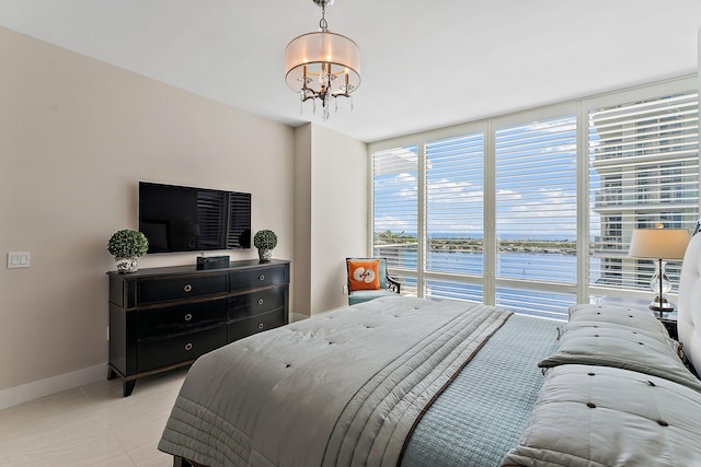 bedroom featuring floor to ceiling windows and a chandelier