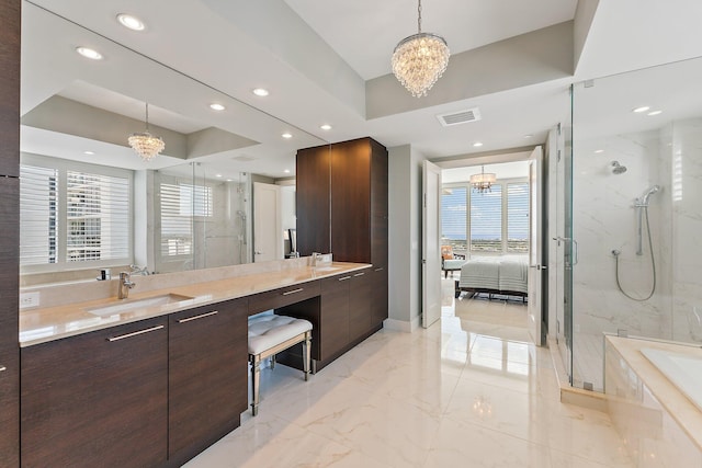 bathroom featuring shower with separate bathtub, vanity, a tray ceiling, and a notable chandelier